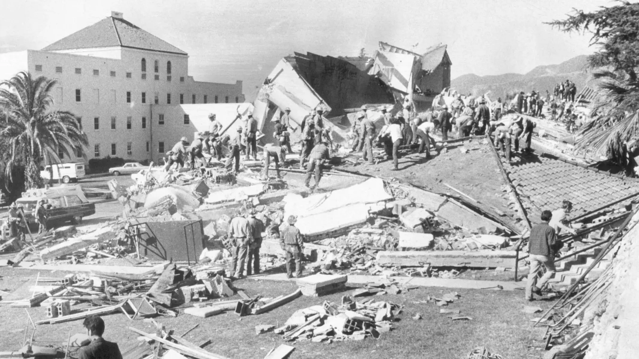 Rescuers stand on the ruins of the collapsed San Fernando Veterans Administration Hospital.